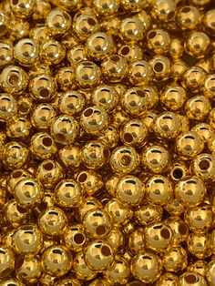 many shiny gold beads are shown in this image