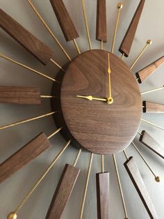 a wooden clock with gold hands and numbers on it