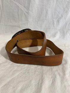 "Measurements in inches: Long: 46\" Deep: 1\"7 First perforation from buckle is 34\" and 40\" on the last Buckle measurements W: 5 H: 3\"2 Condition: -Good Pre-owned condition for its age -Buckle shows normal sings or wear from use -Belt is clean Shipping: -All purchases are sent within 1-2 business days -I send all the domestic purchases via USPS Priority mail and include a tracking number (emailed upon request). If you need an extra service please request it once you purchase your item -For in Western Leather Belts For Formal Occasions, Western Style Leather Belt For Formal Wear, Classic Antique Belt Buckles For Ranch, Classic Leather Belt Buckles For Rodeo, Classic Leather Belt Buckle With Antique Design, Vintage Bridle Leather Belt With Antique Buckle, Vintage Bridle Leather Belt With Brass Buckle, Classic Brown Belt For Ranch, Rustic Leather Belt Buckle With Removable Belt