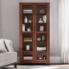 a living room with a white chair and bookcase