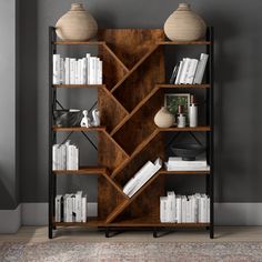 a bookshelf filled with lots of books on top of a wooden floor next to a wall