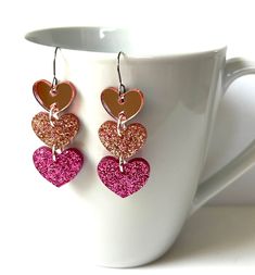 Love these light pink heart shape sparkle confetti resin dangle earrings!  You will get so many compliments when you wear these! The earrings are made with clear resin and large sparkly multi color glitter. The top heart has a pink mirror effect. These fun dangle earrings are lightweight and sassy! Please take these earrings off when jumping in water.  They are water resistant, but will last longer if kept out of being drenched by water. Clear Mirror, Wood Resin Jewelry, Pink Mirror, Bold Earrings, Heart Dangle Earrings, Pink Sparkle, Fabric Ribbon, Clear Resin, Organza Bags