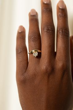 a woman's hand with a gold ring on it and a diamond in the middle