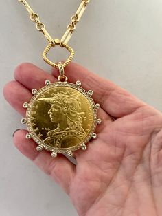 Beautiful reproduction vintage coin pendant, French Madagascar coin in a bezel with cubic zirconia stones. The bale attached to the coin is also encrusted with CZ stones. The coin is 22k gold plated and elegantly hangs from a multi link gold plated brass chain and a rope design spring lock clasp. The spring lock closure not only makes it easy to open and close the necklace for those with difficulty but adds to the creativity of the jewelry piece. Please see photograph of how to open the clasp. W Ginni Ring, Pendant Necklace Outfit, Roman Coin Jewelry, Gold Coin Jewelry, Coin Frame, Coin Jewellery, Large Pendant Necklace, Coin Design, Gold Coin Necklace