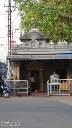 a man is standing in the doorway of a temple with a motorcycle parked next to it