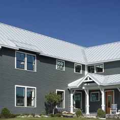 a large gray house with white trim on the front and side of it's windows