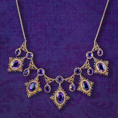 A majestic antique Victorian necklace featuring a fabulous gallery consisting of eleven droppers and sixteen deep purple amethysts that range from approx. 0.80ct to 6ct (approx. 32ct total). Each stone is bezel set with a rope edge and surrounded by beautiful, scrolling cannetille metalwork all fashioned in 18ct gold.  Amethyst is the birthstone of February and is considered a stone of protection, clarity and tranquillity. Its deep violet colouring has been highly esteemed throughout history, ad Victorian Jewelry Necklace, British Crown Jewels, Edwardian Engagement Ring, Victorian Jewellery, Antique Jewellery Online, Victorian Necklace, Antique Vintage Jewelry, Crown Jewels, Amethyst Necklace