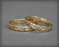 two gold wedding rings sitting next to each other