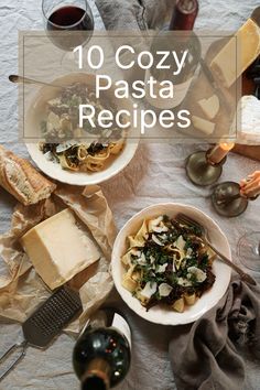 two bowls of pasta with cheese and bread on the side, next to some wine glasses