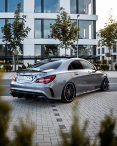 a silver mercedes cla parked in front of a building