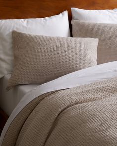 a close up of a bed with pillows and blankets