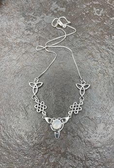 "I've fabricated a Celtic Irish inspired necklace with a center Celtic knot which features a center 8mm round cabochon, of your choosing in the drop down menu, with a total of three component pieces on either side. The sterling chain of 16 inches is soldered to each end making the approximate length of this piece just a bit over 18\" total. The chain will have a sturdy lobster claw. I've fabricated everything in sterling silver - it's a heirloom piece! This is a beautiful and feminine statement Teardrop Cabochon Necklace For Anniversary, Moonstone Cabochon Round Pendant Necklace, Anniversary Cabochon Teardrop Necklace, Anniversary Teardrop Cabochon Necklace, Unique Cabochon Necklaces For Wedding, Adjustable Cabochon Round Pendant Necklace, Irish Necklace, Irish Wedding, Inspired Necklace