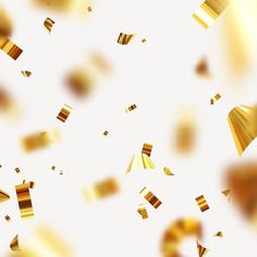 gold confetti falling down into the air on a white and yellow background with blurry edges