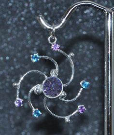 "This nebula small pendant in sterling silver with amethyst, titanium druzy quartz and apatite swirls with the whirlwind motion of space dust, space clouds and space ions. Amethyst, apatite and the beauty of fine quartz crystals coated with anodized titanium is just the right galactic combo of elements. This light and bright eye-catching piece will be a constant reminder that you are made of star stuff! This pendant is 1 1/8\" (28 mm) from top to bottom and 1\" (25 mm) at the widest point. At th Purple Fusion Style Round Jewelry, Silver Celestial Multi-stone Jewelry, Silver Multi-stone Celestial Jewelry, Celestial Silver Jewelry With Sparkling Stones, Celestial Style Silver Jewelry With Sparkling Stones, Purple Sterling Silver Fusion Jewelry, Silver Spiral Gemstone Jewelry, Celestial Multi-stone Sterling Silver Jewelry, Hypoallergenic Silver Amethyst Jewelry