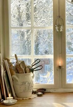 kitchen utensils are in a white bowl by the window