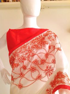 "Stunning half white semi silk saree with intricate all over embroidery and semi raw silk unstiched blouse in reddish orange. The red color thread embroidery is simply stunning aginst offwhite. The entire embroidery is hand worked and the floral border extends more in the front, pallu and the pleats. Saree length 5.5 meters Blouse fabric 1 meter 44\" wide Saree ships in 2-3 days of payment. Delivery within 4-5 days of shipment all over the world. We also offer blouse and petticoat stitching for Raw Silk Blouse, All Over Embroidery, Floral Borders, Raw Silk Saree, Floral Border, Blouse Fabric, Raw Silk, Petticoat, Silk Blouse