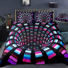 a bed covered in a colorful comforter and pillows