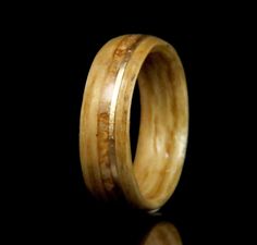 a wooden ring that is made out of wood and has gold inlays on it