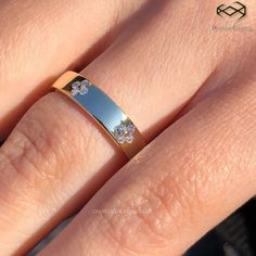 a close up of a person's hand with a wedding ring on their finger