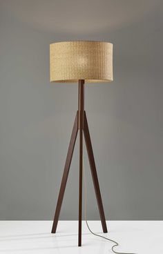 Truly a mix of design and functionality that doesnt compromise on style, this 59 inc tripod floor lamp with brown drum shade will be a great addition to your space. The lamp shade itself has a drum shape and is made of wicker rattan, which makes it a perfect choice. A sturdy three leg base gives this tripod style floor lamp a designer style that leans towards modern and industrial for a unique and stylish look. The light that this lamp throws is soft and warm to elevate the look of most any space in your home. The perfect lamp to create just the right natural and soothing light in your space. 59 inc H x 18.5 inc W x 18.5 inc D. HomeRoots 59-in Walnut Tripod Floor Lamp | 4000372867 Walnut Wood Floors, Affordable Lighting, Natural Wood Flooring, Tripod Floor Lamp, Wood Floor Lamp, Natural Paper, Tripod Floor Lamps, Luz Natural, Tripod Lamp