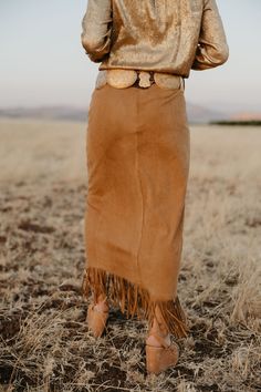 This fringed, flowing skirt pays tribute to Lily’s ties to Nevada. With a touch of Western elegance, it captures the beauty of the landscapes that inspired it. Perfect for cowgirls who blend heritage with high fashion, this skirt moves with you, just like the wind over the Nevada sagebrush. True to Size Little to Medium Stretch Faux Suede Fringe Detailing Ankle Length Skirt Fitted Bohemian Maxi Skirt For Fall, Bohemian Lined Maxi Skirt For Fall, Bohemian Fitted Skirt With Frayed Hem, Bohemian Fringe Bottoms For Fall, Western Skirts Long, Elegant Fringe Skirt For Fall, Chic Long Skirt With Frayed Hem, Western Long Skirt, Chic Fall Skirt With Frayed Hem