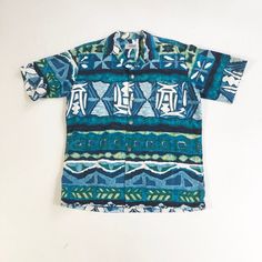 "1950's Hawaiian bark cloth shirt has a button front with silver Greek coin style buttons, and a chest pocket. Label is Andrade Resort Shops Waikiki. Made in Hawaii. Condition Excellent overall, has a faint small stain at the bottom of the pocket. Measurements Chest 44\" Waist 42\" Shoulder 18\" Sleeve length 10\" Length 28\" Best for a size medium." Retro Blue Button-up Hawaiian Shirt, Retro Blue Collared Hawaiian Shirt, Vintage Blue Cotton Camp Shirt, Blue Retro Hawaiian Button-up Shirt, Retro Collared Hawaiian Shirt With Button Closure, Vintage Blue Hawaiian Shirt With Camp Collar, Blue Retro Button-up Camp Shirt, Retro Blue Button-up Camp Shirt, Vintage Blue Button-up Hawaiian Shirt