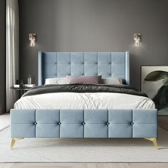 a bed with blue upholstered headboard and foot board in a gray bedroom