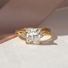 a gold ring with a princess cut diamond