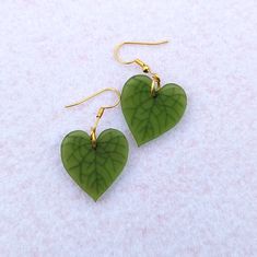 Simple heartleaf earrings. Green heart shaped earrings with engraved leaf veins. Shiny reflective studs that are half an inch and matte drop earrings hanging from a shiny gold leaf stud. These make a great low key Valentine's Day gift, especially if you don't like pink or red! Alternatively, they're for the plant lover in your life. The studs are also a nice unisex gift option. Choose the mini studs or the dangle earrings with default studs, fishhooks, huggies (leverbacks), or clip-ons. Dangle e Fun Jewelry Aesthetic, Simple Clay Earrings, Diy Earrings Dangle, Alternative Earrings, Cute Dangle Earrings, Leaf Veins, Plant Earrings, Earrings Hanging, Novelty Earrings