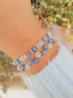 a close up of a person wearing a bracelet with flowers on it