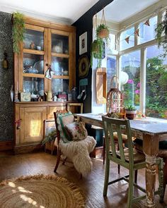 a room filled with lots of furniture next to a window covered in potted plants