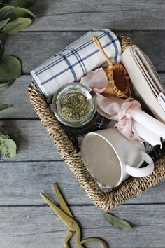 a basket filled with kitchen items on top of a wooden table next to scissors and napkins