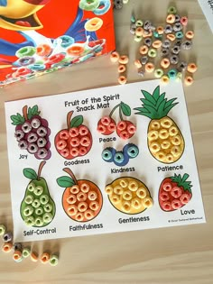 fruit of the spirit snack magnets and beads on a table next to a book