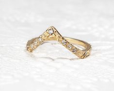 a close up of a gold ring with diamonds on it's sides and an arrow shaped design in the middle