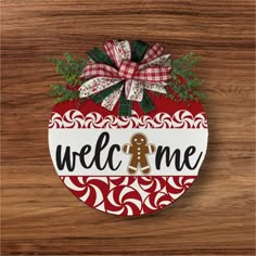 a wooden sign that says welcome with a gingerbread man in the center on it