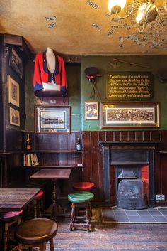 the interior of a pub with wooden tables, chairs and a fire place in it