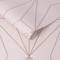 a pink wallpaper with lines on it and a roll of tape next to it