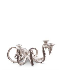 two silver candlesticks sitting next to each other on top of a white surface