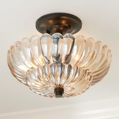 a close up of a light fixture with clear glass petals on the top and bottom