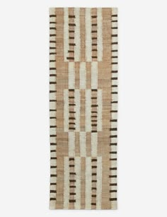 a beige and black striped rug on a white wall