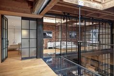 the interior of an office building with glass walls and wood flooring, exposed ceiling