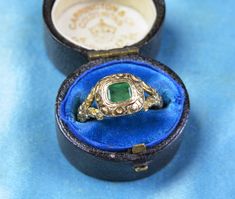 A beautiful ornately detailed antique, rococo style ring set with an alluring green emerald in a foliate engraved setting between floral split shoulders. A perfect addition to any jewellery lovers collection. ~Details~ ERA: Antique early 1900's, Georgian rococo style.  THE GEMS: Set with a vibrant green natural emerald, measures in setting 4.6mm x 5.2mm. MEASUREMENTS: Size O Uk or 7 1/4. Face measures 10mm x 11mm, shoulders measure 9mm tapering to 3.5mm. WEIGHT: 4 grams. MATERIALS: 18ct gold, Emerald.  CONDITION: Very good antique condition, emerald not original to ring but added at some point in antiquity.  HALLMARKS:  Chester, 18ct, 1903. Any more pics or questions please don't hesitate to contact me. Follow @nephelesgold on Instagram for more pics and other stunning vintage and antique Antique Green Emerald Cut Ring, Antique Green Emerald-cut Emerald Ring, Antique Green Emerald Cut Emerald Ring, Antique Emerald Cut Green Emerald Ring, Victorian Gold Emerald Ring, Victorian Emerald Ring In Yellow Gold, Antique Green Ring With 17 Jewels, Victorian Yellow Gold Emerald Ring, Antique Gold Emerald Ring With Intricate Design