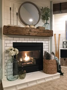 a fireplace with a mirror above it and a basket on the mantle next to it