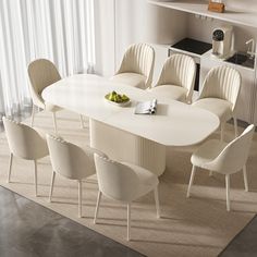 a white table with six chairs and a bowl of fruit on the table in front of it