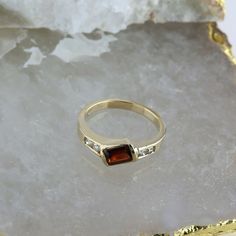 14K Yellow Gold Garnet and Diamond Ring, garnet rectangular offset 4 round diamond side stones, .25 inch across, Ring size 6.75, Circa 1970, 3.4 grams SKU # BB256R27 Most rings are sizable for a small fee. If the ring you are considering is the incorrect size contact us for a quote. This listing contains photographs of the actual item you will receive. Our items are in excellent condition with little or no signs of wear and many are one of a kind pre-owned estate finds. Please look closely at th Formal Multi-stone Rectangular Ring, Elegant Multi-stone Rectangular Rings, Elegant Rectangular Multi-stone Rings, Yellow Gold Rectangular Channel Set Rings, Rectangular Yellow Gold Rings Channel Set, Rectangular Channel Set Yellow Gold Ring, Classic Brown Rectangular Jewelry, Classic Multi-stone Princess Cut Rings, Three Stone Garnet Jewelry For Anniversary