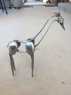 a metal giraffe sculpture sitting on top of a cement floor