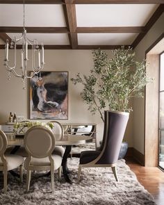 a dining room with a chandelier hanging from the ceiling and a painting on the wall