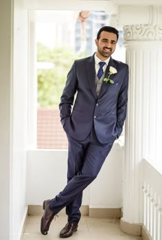 a man in a suit and tie leaning against a wall