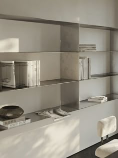 an empty room with some books on the shelves and a chair in front of it