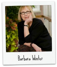 a woman with glasses is sitting on the steps in front of some potted plants